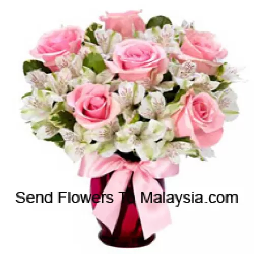 Roses roses et alstroemeria blanche arrangées magnifiquement dans un vase en verre