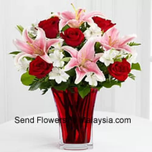 6 roses rouges et 5 lys roses avec des remplissages saisonniers dans un beau vase en verre